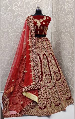 Here Is A Beautiful Designer Bridal Lehenga Choli In Maroon Color?Paired With Red Colored Dupatta. This Beautiful Heavy Lehenga Choli Is Fabricated On Velvet Paired With Net Fabricated Dupatta. It Is Beautified With Heavy Detailed Embroidery. Get Ready For Your D-Day With This Designer Piece And Look The Most Graceful Of All.