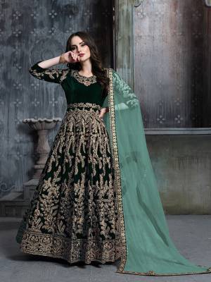 Get Ready For The Upcoming Wedding And Festive Season Wearing This Heavy Designer Floor Length Suit  In Dark Green Color Paired With Light Green Colored Dupatta. Its Heavy Embroidered Top Is Fabricated on Velvet Paired With Santoon Bottom And Net Fabricated Dupatta. 