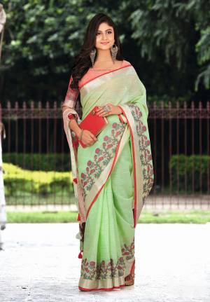 Flaunt Your Rich And Elegant Taste Wearing This Pretty Saree In Light Green Color Paired With Red Colored Blouse. This Saree And Blouse Are Fabricated On Linen Beautified With Floral Weave. It Is Light In Weight And Gives A Rich Look To Your Personality. 