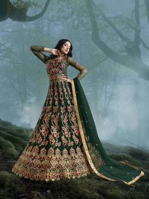 Grab This Heavy Designer Floor Length Suit In Dark Green Color For The Upcoming Wedding Season. This Very Beautiful And Heavy Embroidered Floor Length Top Is Fabricated On Net Paired With Silk based Bottom And Net Fabricated Dupatta. Its Detailed Embroidery With Perfect Color Combination Will Earn You Lots Of Compliments From Onlookers.