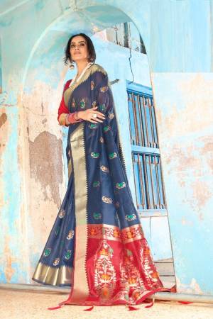 Shine Bright Wearing This Attractive Looking Saree In Navy Blue Color Paired With Contrasting Red Colored Blouse. This Saree And Blouse Are Fabricated On Cotton Silk Beautified With Weave. Buy This Saree Now.