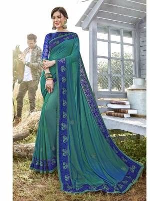 Celebrate This Festive Season Wearing This Designer Saree In Teal Green Color Paired With Contrasting Royal Blue Colored Blouse. This Saree Is Fabricated On Satin Georgette Paired With Art Silk Fabricated Blouse. 