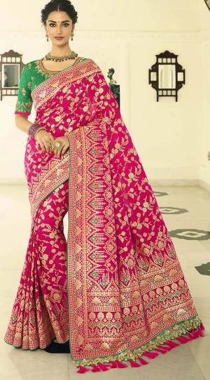 For A Proper Traditional Look, Grab This Designer Saree In Rani Pink Color Paired With Contrasting Green colored Blouse. This Heavy Weaved Saree Is Banarasi Art Silk Based Paired With Art Silk Fabricated Heavy Embroidered Blouse. Buy This Saree Now.