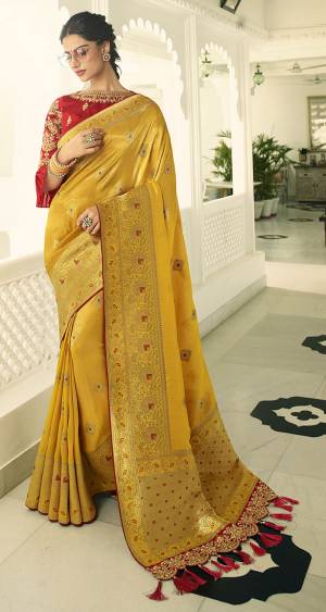 For A Proper Traditional Look, Grab This Designer Saree In Yellow Color Paired With Contrasting Red colored Blouse. This Heavy Weaved Saree Is Banarasi Art Silk Based Paired With Art Silk Fabricated Heavy Embroidered Blouse. Buy This Saree Now.