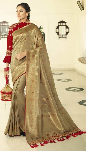 Celebrate This Festive Season In A Lovely Traditional Look With This Heavy Designer Saree In Beige Color Paired With Red Colored Blouse. This Saree Is Fabricated on Banarasi Art Silk Beautified With Heavy Weave Paired with Art Silk Fabricated Blouse Beautified With heavy Embroidery.