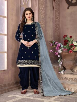 Grab This Beautiful Designer Patiala Suit In Navy Blue Color Paired With Contrasting Grey Colored Dupatta. Its Embroidered Top Is Fabricated on Velvet Paired Santoon Bottom And Net Fabricated Dupatta. Buy Now.