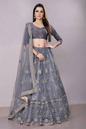 This Wedding Season, Look The Most Graceful Of All Wearing This Heavy Designer Elegant Lehenga Choli In Grey Color. Its Blouse, Lehenga And Dupatta are Fabricated on Net Beautified With Tone To Tone Coding And Resham Embroidery With Stone Work. Buy Now