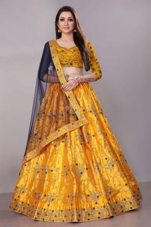 Get Ready For The Upcoming Wedding Season With This Heavy Designer Lehenga Choli In Yellow Color Paired With Contrasting Navy  Blue Colored Dupatta. This Pretty Heavy Embroidered And Attractive Lehenga Choli Is Fabricated on Satin Silk Paired With Net Fabricated Dupatta. Its Detailed Embroidery And Color Pallete Will earn You Lots Of Compliments From Onlookers.