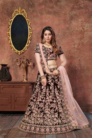 Here Is A Prefect Heavy Bridal Lehenga Choli In Maroon Color Paired With Contrasting Peach Colored Dupatta. This Beautiful Heavy Embroidered Lehenga Choli Is Fabricated On Velvet Paired With Net Fabricated Dupatta. Buy This Heavy Designer Piece Now.