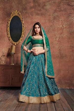 Get Ready For The Upcoming Wedding Season With This Designer Lehenga Choli In Blue Colored Lehenga And Dupatta Paired With Green Colored Blouse. This Lehenga Choli Is Fabricated On Art Silk Paired With Net Fabricated Dupatta. 