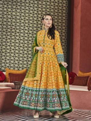 Give An Enhanced Traditional Look To Your Personlity Wearing This Designer Readymade Floor Length Suit In Yellow Color Paired With Contrasting Green Colored Dupatta. Its Digital Printed Top Is Silk Based Paired With Cotton Crepe Fabricated Bottom And Net Fabricated Dupatta Which Is Beautified With Sequence Work. 
