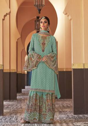 Adorn The Seasons Trend With This Trendy Designer Sharara Suit In Turquoise Blue Color. Its Top Is Fabricated On Georgette Paired With Crepe Satin Bottom And Chiffon Fabricated Dupatta. This Lovely Suit Is Beautified With Detailed Attractive Prints And Stone Work. Buy This Lovely Piece Now.