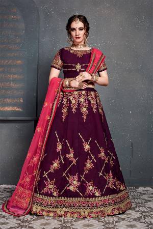 Grab This Heavy Designer Lehenga Choli For This Wedding Season In Wine Color Paired With Contrasting Dark Pink Colored Dupatta. This Pretty Lehenga Choli Is Satin Silk Based Paired With Net Fabricated Dupatta. Buy This Piece Now.