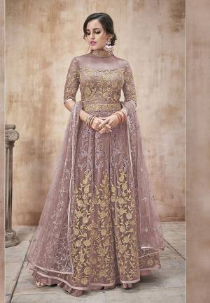 Add This New Shade In Pink To Your Wardrobe With This Designer Floor Length Suit In Dusty Pink Color. Its Heavy Embroidered Top And Dupatta Are Net Based Paired With Satin Silk Bottom. Buy Now.