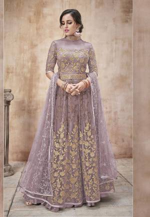 Add This New Shade In Purple To Your Wardrobe With This Designer Floor Length Suit In Lilac Color. Its Heavy Embroidered Top And Dupatta Are Net Based Paired With Satin Silk Bottom. Buy Now.