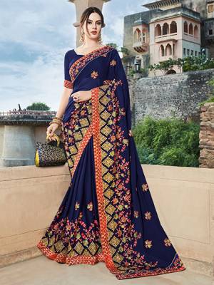 Get Ready For The Upcoming Wedding And Festive Season With This Designer Saree In Royal Blue Color Paired With Contrasting Dark Pink Colored Blouse. This Heavy Embroidered Saree Is Georgette Based Paired With Art Silk Fabricated Blouse. 