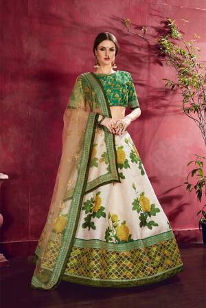 Here Is A Very Pretty Designer Lehenga Choli With Attractive Floral Digital Prints In Dark Green Colored Blouse Paired With Off-White Colored Lehenga And Cream Colored Dupatta. This Lehenga Choli Is Art Silk Based Paired With Net Fabricated Dupatta. 