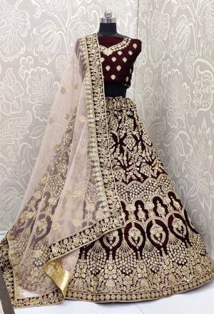 Here Is A Beautiful Designer Bridal Lehenga Choli In Dark Maroon Color Paired With Light Pastel Pink Colored Dupatta. This Beautiful Heavy Lehenga Choli Is Fabricated On Velvet Paired With Net Fabricated Dupatta. It Is Beautified With Heavy Detailed Embroidery. Get Ready For Your D-Day With This Designer Piece And Look The Most Graceful Of All