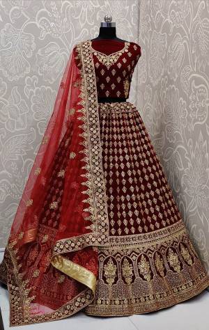 Here Is A Beautiful Designer Bridal Lehenga Choli In Maroon Color Paired With Red Colored Dupatta. This Beautiful Heavy Lehenga Choli Is Fabricated On Velvet Paired With Net Fabricated Dupatta. It Is Beautified With Heavy Detailed Embroidery. Get Ready For Your D-Day With This Designer Piece And Look The Most Graceful Of All.