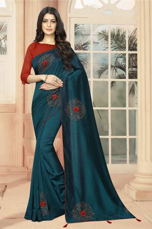 Add Some Semi-Casuals With This Pretty Designer Saree In Teal Blue Color Paired With Red Colored Blouse. This Saree And Blouse are Fabricated On Art Silk Beautified With Stone Work And 3D Flowers. This Saree Is Light Weight And Easy To Carry All Day Long .