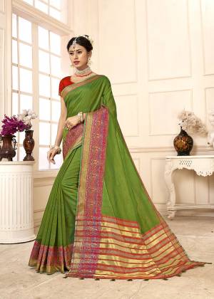 Celebrate This Festive Season With Beauty And Comfort In This Designer Green Colored Saree Paired With Contrasting Red Colored Blouse. This Saree Is Cotton Silk Based Paired With Art Silk Fabricated Blouse. 