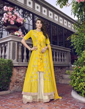 Here Is A Lovely Four Piece Designer Indo-Western Dress In Yellow And Cream Color. Its Top Is Fabricated on Art Silk Which Comes With An Embroidered Jacket Fabricated On Tussar Silk Paired With Crepe Fabricated Bottom and Chiffon Dupatta. Buy Now.