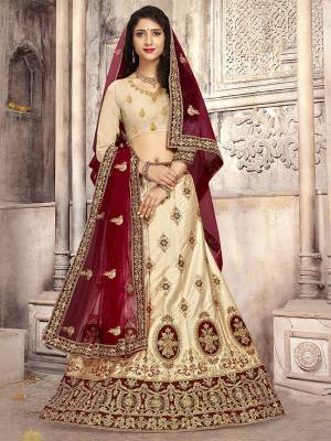 Look The Most Gorgeous Of All This Wedding Season With This Heavy Designer Lehenga Choli In Cream Color Paired With Contrasting Maroon Colored Dupatta. Its Blouse Is Fabricated on Art Silk Paired With Satin Silk Lehenga And Net Fabricated Dupatta. Buy This Semi-Stitched Lehenga Choli Now.