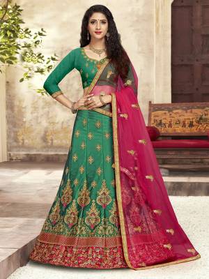 For A Proper Traditional Look, Grab This Heavy Designer Lehenga Choli In Green Color Paired With Contrasting Rani Pink Colored Blouse. Its Blouse Is Fabricated On Art Silk Paired With Satin Silk Lehenga And Net Fabricated Dupatta. It Is Beautified With Attractive Embroidery. Buy This Pretty Piece Now.