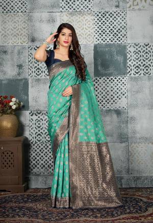 Grab This Beautiful Designer Silk Based Saree In Sea Green Color Paired With Contrasting Navy Blue Colored Blouse. This Saree And Blouse Are Fabricated On Banarasi Art Silk Beautified With Weave All Over. 