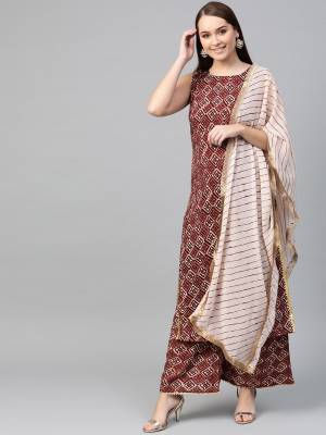 Simple And Elegant Looking Readymade Printed Suit Is Here In Brown Color Paired With Cream Colored Dupatta. Its Top And Bottom Are Fabricated On Rayon Paired With Georgette Fabricated Dupatta. 