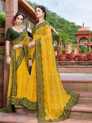 Celebrate This Festive And Wedding Season Wearing This Heavy Designer Saree In Yellow Color Paired With Contrasting Dark Green Colored Blouse. This Saree Is Fabricated On Georgette Paired With Art Silk Fabricated Blouse. Buy Now.