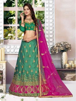 For A Proper Traditional Look, Grab This Heavy Designer Lehenga Choli In Green Color Paired With Contrasting Rani Pink Colored Blouse. Its Blouse Is Fabricated On Art Silk Paired With Satin Silk Lehenga And Net Fabricated Dupatta. It Is Beautified With Attractive Embroidery. Buy This Pretty Piece Now.