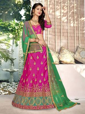 For A Proper Traditional Look, Grab This Heavy Designer Lehenga Choli In Rani Pink Color Paired With Contrasting Green Colored Blouse. Its Blouse Is Fabricated On Art Silk Paired With Satin Silk Lehenga And Net Fabricated Dupatta. It Is Beautified With Attractive Embroidery. Buy This Pretty Piece Now.