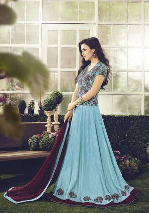 Get ready For The Upcoming Wedding And Festive Season With This Designer Floor Length Suit In Blue Color Paired With Wine Colored Dupatta. This Suit Is Cotton Based Beautified With Detailed Embroidery.