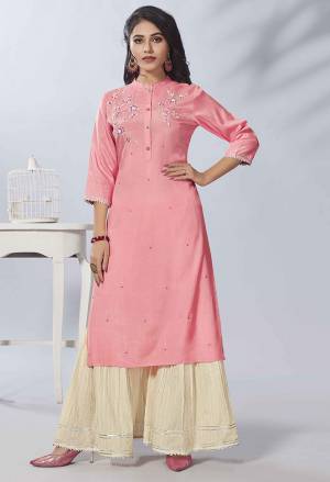 Celebrate This Festive Season With Beauty And Comfort Wearing This Designer Readymade Kurti In Pink Color Paired With Cream Colored Bottom. This Hand Embroidered kurti Is Fabricated on Viscose Rayon Paired With Cotton Bottom. 