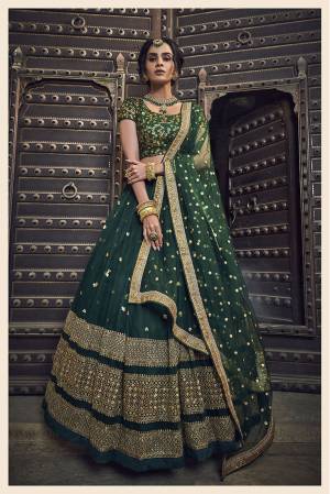 You Will Definitely Earn Lots Of Compliments Wearing This Heavy Designer Lehenga Choli In All Over Dark Green Color. This Pretty Lehenga, Choli And Dupatta Are Net based Beautified With Attractive Embroidery. 