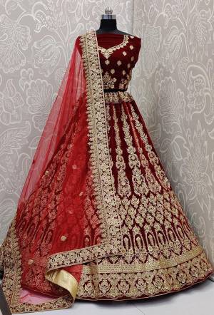 Be The Trendy Bride Wearing This Heavy designer Lehenga Choli In Maroon Color Paired With Red Colored Dupatta. Its Blouse And Lehenga Are Fabricated On Velvet Paired With Net Fabricated Dupatta. Buy Now.