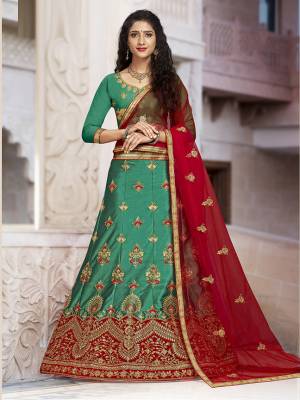 For A Proper Traditional Look, Grab This Heavy Designer Lehenga Choli In Green Color Paired With Contrasting Red Colored Blouse. Its Blouse Is Fabricated On Art Silk Paired With Satin Silk Lehenga And Net Fabricated Dupatta. It Is Beautified With Attractive Embroidery. Buy This Pretty Piece Now.
