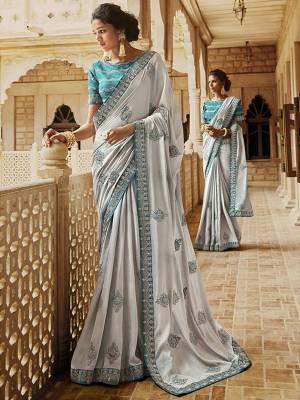 Simple And elegant Looking Heavy Designer Saree IS Here In Light Grey Color Paired With Contrasting Blue Colored Blouse .This Pretty Saree IS Satin Based Paired With Art Silk Fabricated Blouse. Buy This Elegant Looking Saree Now.