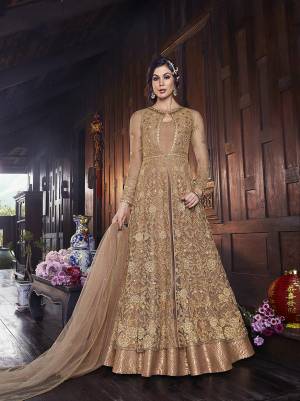 Flaunt Your Rich And Elegant Taste In This Lovely Designer Indo-Western Suit In Beige Color. It Has Elegant Looking Floor Length Gown Fabricated on Art Silk With Embroidered Net Fabricated Jacket Paired With Art Silk Fabricated bottom And Net Dupatta. 