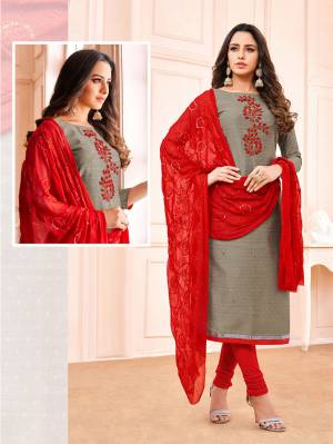 You Will Definitely Earn Lots Of Compliments Wearing This Designer Straight Suit In Grey Colored Top Paired With Contrasting Red Colored Bottom And Dupatta. Its Embroidered Top Is Fabricated On Jacquard Cotton Paired With Cotton Bottom And Chiffon Dupatta. 