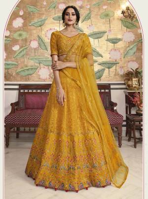Get Ready For Upcoming Wedding Season Wearing This Heavy Designer Lehenga Choli In Musturd Yellow Color. Its Blouse Is Fabricated On Soft Silk Paired With Soft Silk And Net Fabricated Lehenga Paired With Net Fabricated Dupatta. It Is Beautified With Heavy Embroidery Over Blouse , Lehenga And Dupatta. 
