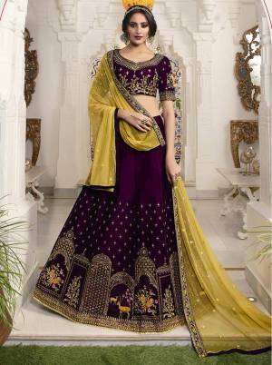 For A Royal Look, Grab This Elegant Heavy Designer Lehenga Choli In Wine Color Paired With Contrasting Yellow Colored Dupatta. This Lehenga Choli IS Fabricated On Velvet Beautified With Traditional Pattern Embroidery Paired With Net Fabricated Dupatta. Its Rich Color Pallete And Fabric Will Give A Royal Look Like Never Before. 