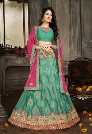 For A Proper Traditional Look, Grab This Heavy Designer Lehenga Choli In All Sea Green Color Paired With Contrasting Pink Colored Dupatta. Its Blouse Is Fabricated On Art Silk Paired With Jacquard Net Lehenga And Chiffon Fabricated Dupatta. It Is Beautified With Attractive Embroidery. Buy This Pretty Piece Now.