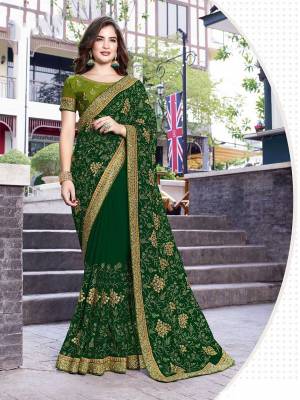 Catch All The Limelight At The Next Function You Attend Wearing This Lovely Designer Saree In Dark Green Color Paired With Green Colored Blouse. This Pretty Embroidered Saree Is Fabricated On Georgette Paired With Art Silk Fabricated Blouse. 