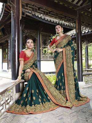 Celebrate This Festive And Wedding Season Wearing This Heavy Designer Saree In Teal Green Color Paired With Red Colored Blouse. This Pretty Saree And Blouse Are Silk Based Beautified With Heavy Embroidery Work. 