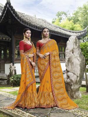 Celebrate This Festive And Wedding Season Wearing This Heavy Designer Saree In Musturd Yellow Color Paired With Red Colored Blouse. This Pretty Saree And Blouse Are Silk Based Beautified With Heavy Embroidery Work. 