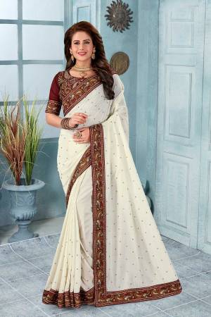 Grab This Heavy Embroidered Saree In Off-White Color. This Saree?And Blouse Are Silk Based Beautified With Multi Colored Kashmiri Embroidery. This Pretty Saree Gives A Rich Look And It Is Suitable For Wedding And Festive Season. Buy Now.