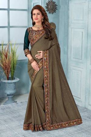 Here Is A Very Pretty Kashmiri Embroidered Designer Saree In Dusty Brown Color. This Pretty Saree And Blouse Are Silk Based With Heavy Embroidered Multi Colored Thread Embroidery With Stone Work.