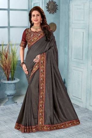 Grab This Heavy Embroidered Saree In Dark Grey Color. This Saree?And Blouse Are Silk Based Beautified With Multi Colored Kashmiri Embroidery. This Pretty Saree Gives A Rich Look And It Is Suitable For Wedding And Festive Season. Buy Now.